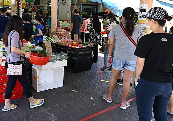 Lidé v Singapuru čekají, až budou puštěni na trh v rámci opatření proti šíření...