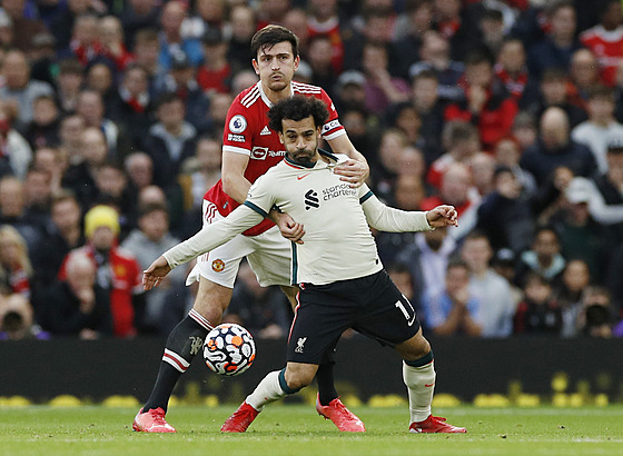 Harry Maguire (vzadu) z Manchesteru United přidržuje Mohameda Salaha z...
