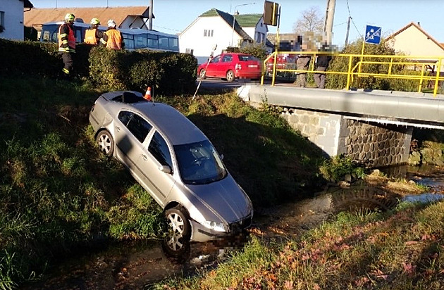 Řidič autobusu nedobrzdil, náraz odhodil auto před ním do potoka