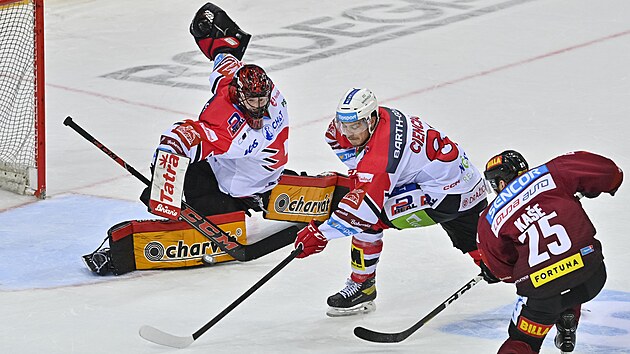 Utkn 18. kola hokejov extraligy: HC Sparta Praha - HC Dynamo Pardubice. Brank Pardubic Dominik Frodl zasahuje proti anci Davida Kaeho (25).