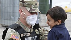 Americký voják s malým Afgháncem na základně Liya v Kosovu (1. října 2021)