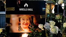 Lidé ped bytem zavradné Mireille Knollové zapalují svíky a pokládají...