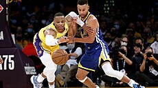 Russell Westbrook (vlevo) z Los Angeles Lakers bojuje o mí se Stephenem Currym...