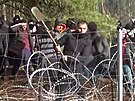 Migranti na polsko-bloruské hranici se snaí proboit plot.