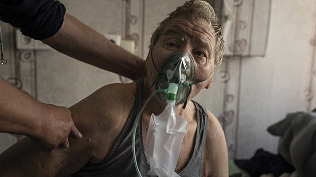 Valerij, pacient s koronavirem, dch za pomoci kyslkov masky na infeknm oddlen v mstsk nemocnici v Doncku. (28. jna 2021)
