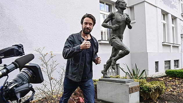 Herec Václav Neužil pózuje při odhalení sochy běžce Emila Zátopka v Praze.