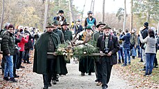 Myslivci skoleného daka nesli na nosítkách ke kapli svatého Huberta v nitru...