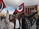 Lidé mávají vlajkami s obrázky zakladatele moderního Turecka Mustafy Kemala...