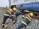 Dr�n� hasi�i likviduj� n�sledky st�etu motorov�ho vozu s p�ek�kou na trati...