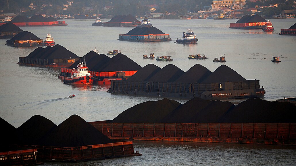 Čluny s uhlím ve frontě na tažení podél řeky Mahakam v Indonésii.