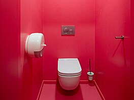 Toalety, diskrétně umístěné za černě natřenými dveřmi, jsou výraznou barevnou...