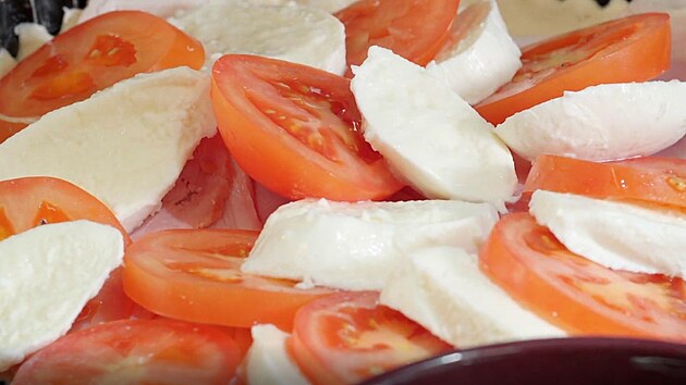 Na vrstvu šunky skládejte kolečka rajčat a mozzarelly.