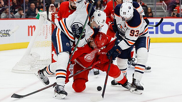 Filip Hronek z Detroitu (dole) nechce ztratil puk, kter� doluj� Warren Foegele a Ryan Nugent-Hopkins (93) z Pittsburghu.