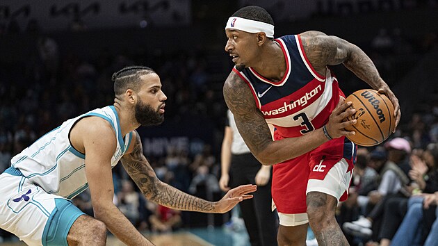 Brnc Cody Martin z Charlotte ve stehu, Bradley Beal z Washingtonu vyml tonou akci.