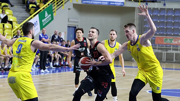 Opavt basketbalist Filip Zbrnek a Mattias Markusson se sna ubrnit nymburskho kdelnka Luke Palyzu.