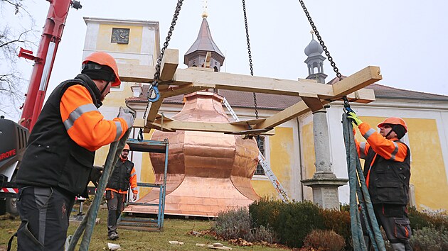 Nov kopule se dokal kostel v Doln Lukavici na Plzesku. Odborn firma vyzvedla md pobitou devnou konstrukci na vrchol kosteln ve. (10. 11. 2021)