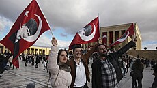 Lidé mávají vlajkami s obrázky zakladatele moderního Turecka Mustafy Kemala...