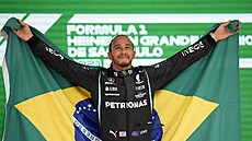 Lewis Hamilton z Mercedesu pózuje s brazilskou vlajkou po vítzné stíhací jízd...