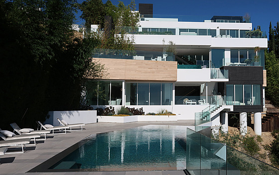 Pohled od bazénu na rezidenci, která vypadá spíš jako bytový dům než obydlí pro...