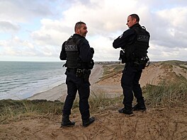 Duny nedaleko Calais. Francouztí policisté pátrají po migrantech pokouejících...