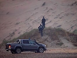 Duny nedaleko Calais. Francouztí policisté pátrají po migrantech pokouejících...