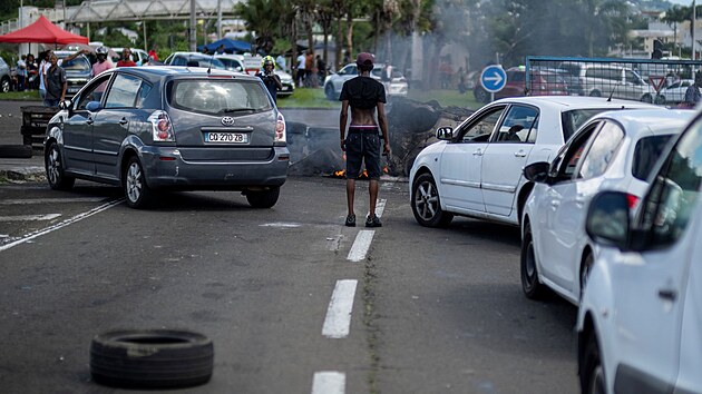 Řidiči na Martiniku se vyhýbají barikádě, kterou na silnici vedoucí k letišti vybudovali demonstranti. Ti nesouhlasí s vládními opatřeními proti covidu. (24. listopadu 2021)