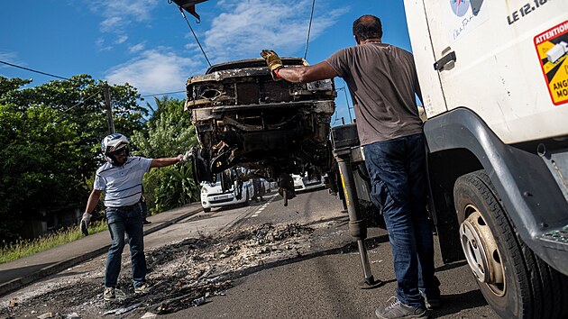 Odtahová služba na Martiniku odklízí vrah zapáleného auta poté, co ostrov zachvátily protesty proti covidovým opatřením. (24. listopadu 2021)