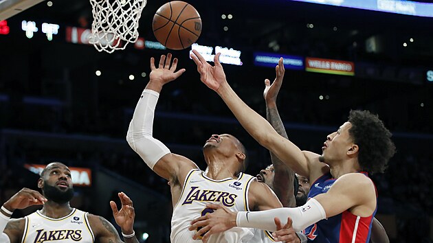 Russell Westbrook (uprostřed) z Los Angeles Lakers bráněný Cadem Cunninghamem z Detroitu.