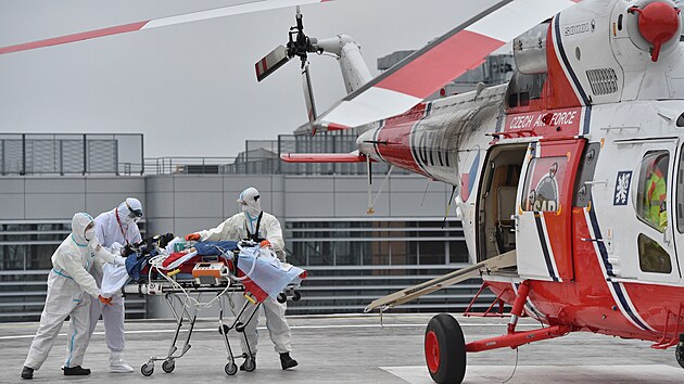 Zdravotníci nakládají 25. listopadu 2021 ve Fakultní nemocnici Brno pacienta s covidem ve vážném stavu do armádního vrtulníku, který ho přepraví do Prahy.