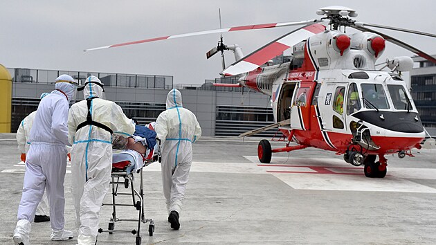 Zdravotníci nakládají 25. listopadu 2021 ve Fakultní nemocnici Brno pacienta s covidem ve vážném stavu do armádního vrtulníku, který ho přepraví do Prahy.