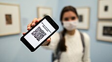 Ruská dívka v muzeu dr�í v rukou chytrý telefon s vyobrazeným QR kódem. (8....