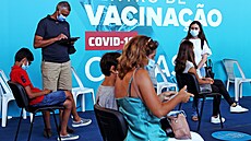 Rodiče s dětmi čekají po první dávce vakcíny v očkovacím centru portugalského...