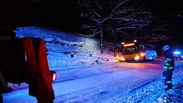 Hasii rno v Teplicch nad Metuj na Nchodsku vythli s pomoc vyproovacho automobilu autobus, kter uvzl na krajnici (30. 11. 2021).