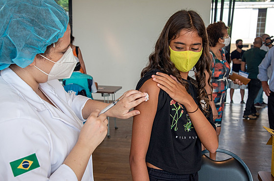 Zdravotnice v brazilském Riu de Janeiru podává dívce vakcínu proti covidu-19....