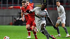 Mohamed Mady Camara z Olympiakosu (v bílém) se p�etla�uje o mí� s Pieterem...