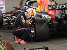Max Verstappen se sklání k pneumatice svého Red Bullu, stal se ampionem...