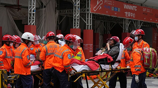 Hasii zachrauj lidi z hongkongskho World Trade Centre, kter bylo zasaeno rozshlm porem. (15. prosince 2021)