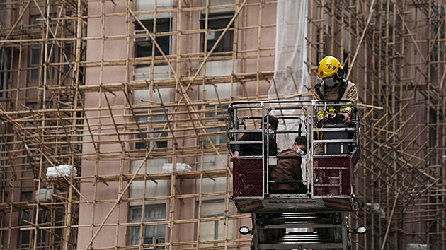 Hasii zachrauj lidi z hongkongskho World Trade Centre, kter bylo zasaeno rozshlm porem. (15. prosince 2021)