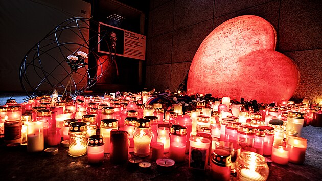 Lidé pokládají svíčky k pamětnímu místu na náměstí Václava Havla u Národního divadla (18. prosince 2021)