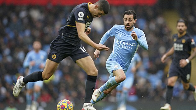 Conor Coady z Wolverhamptonu (vlevo) pronik s mem okolo Bernarda Silvy z Manchesteru City.