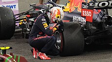 Max Verstappen se sklání k pneumatice svého Red Bullu, stal se ampionem...