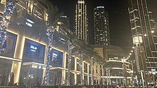 Večer září mrakodrapy i palmy u nákupního centra Dubai Mall.
