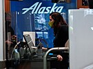 Zamstnankyn letecké spolenosti Alaska Airlines odbavuje zákazníka na...