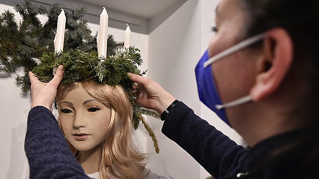 Pracovnice muzea instaluje svce na hlavu sv. Lucie v expozici pibliujc Vnoce ve vdsku.