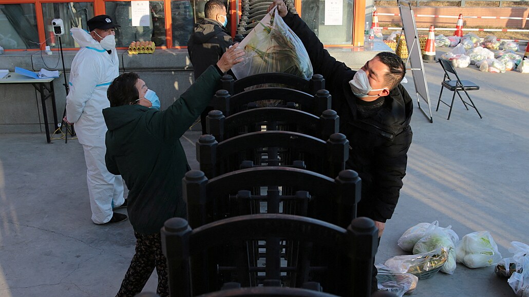 Muž přebírá zásoby potravin. Čínské město Si-an je v lockdownu, obyvatelé trpí...