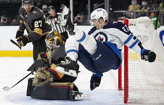 Kristian Reichel (87) z Winnipeg Jets letí kolem gólmana Laurenta Brossoita z...