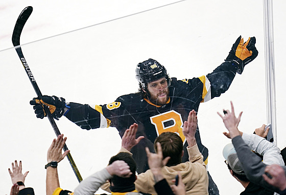 David Pastrák slaví s fanouky Boston Bruins gól proti New Jersey Devils.
