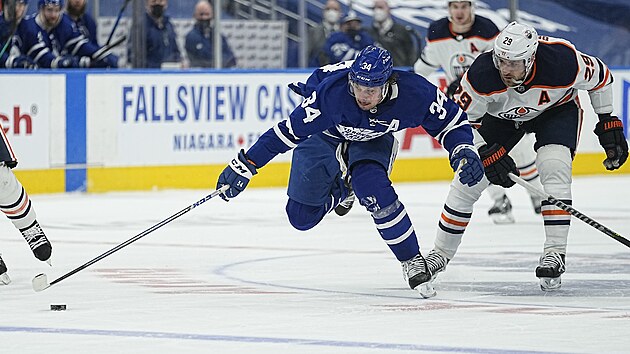 Auston Matthews (34) z Toronto Maple Leafs unik v zpase s Edmonton Oilers, sleduje ho Leon Draisaitl (29).