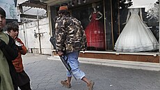 Člen Tálibánu prochází kolem obchodu se svatebními šaty v centru Kábulu. (13....