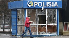 Muž prochází kolem policejní stanice, která byla poničena během masových... | na serveru Lidovky.cz | aktuální zprávy